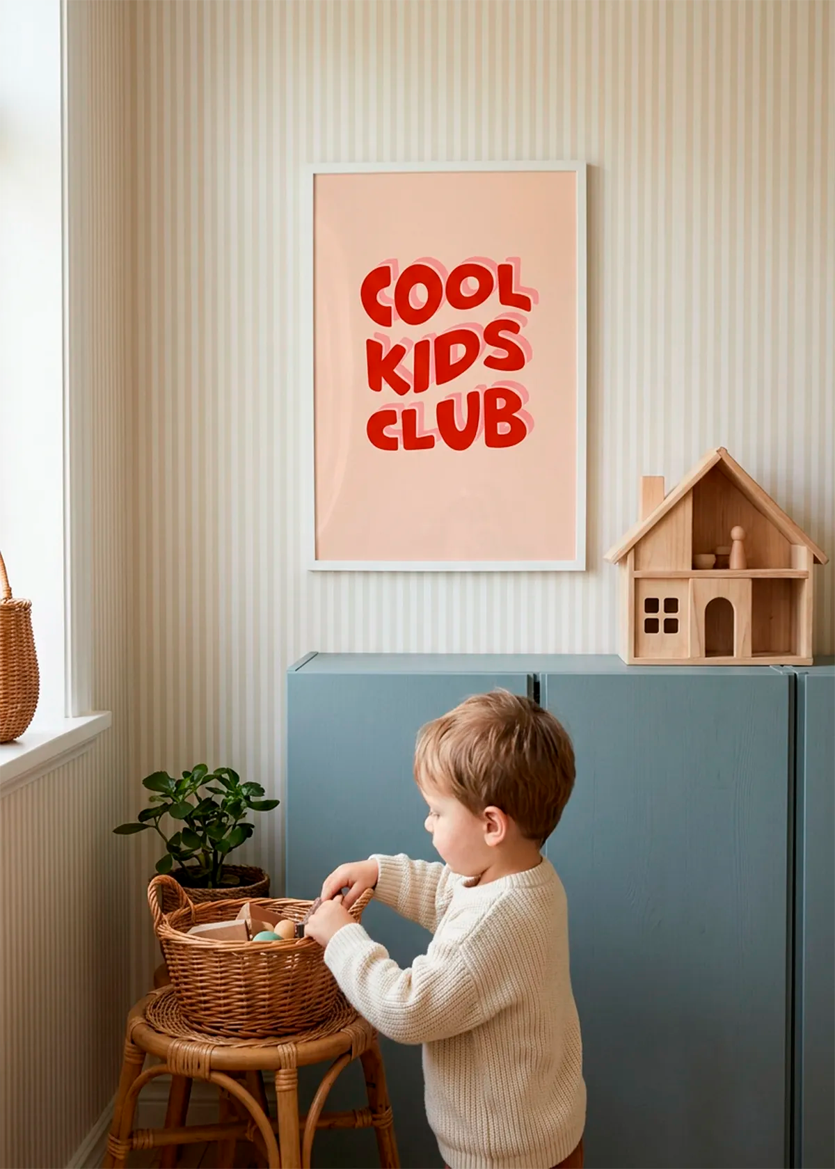 Cool Kids Club art poster by Dominique Vari displayed in a playful kids room with striped wallpaper, blue storage cabinets, wooden toys and soft natural light.