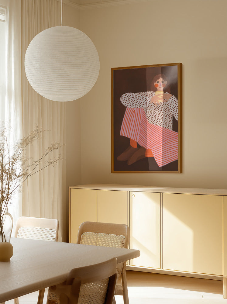 “Cozy Coffee Break” art print by Bea Muller displayed in a dining area with warm light, minimal furniture and Scandinavian styling.