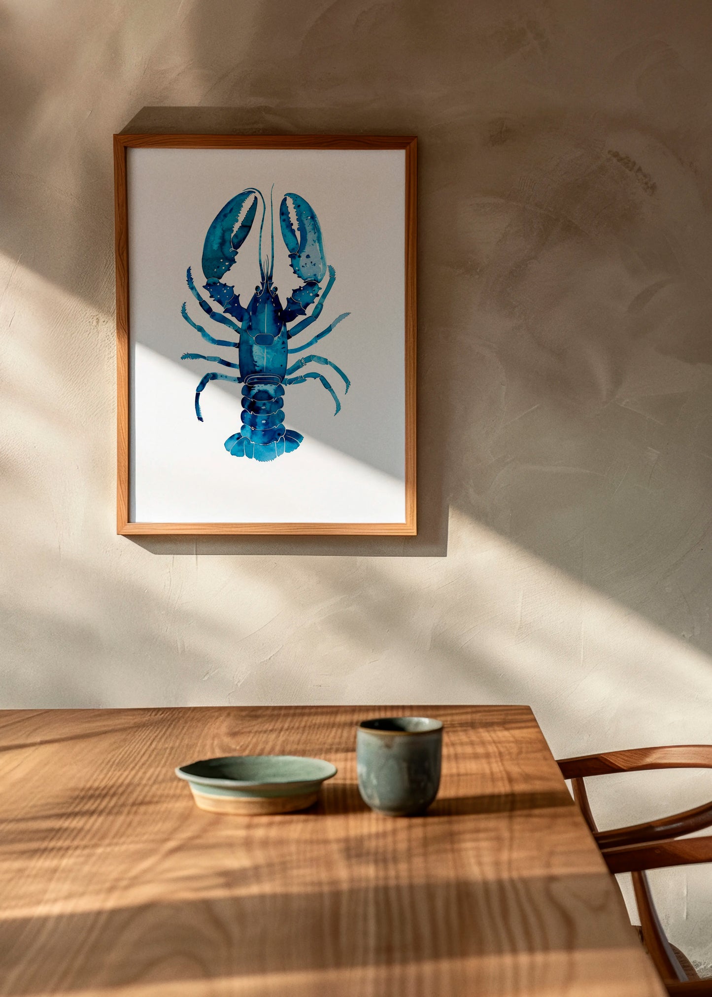 Indigo Lobster art print by Hello Poster in a wooden frame, styled in a warm Scandinavian dining space with natural light and wooden table setting.