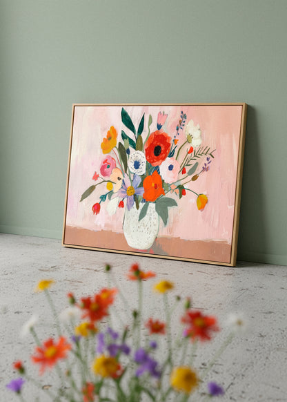 Flowers canvas print by Hello Poster with a bold floral bouquet and pink background, styled against a muted green wall with blurred flowers in the foreground.