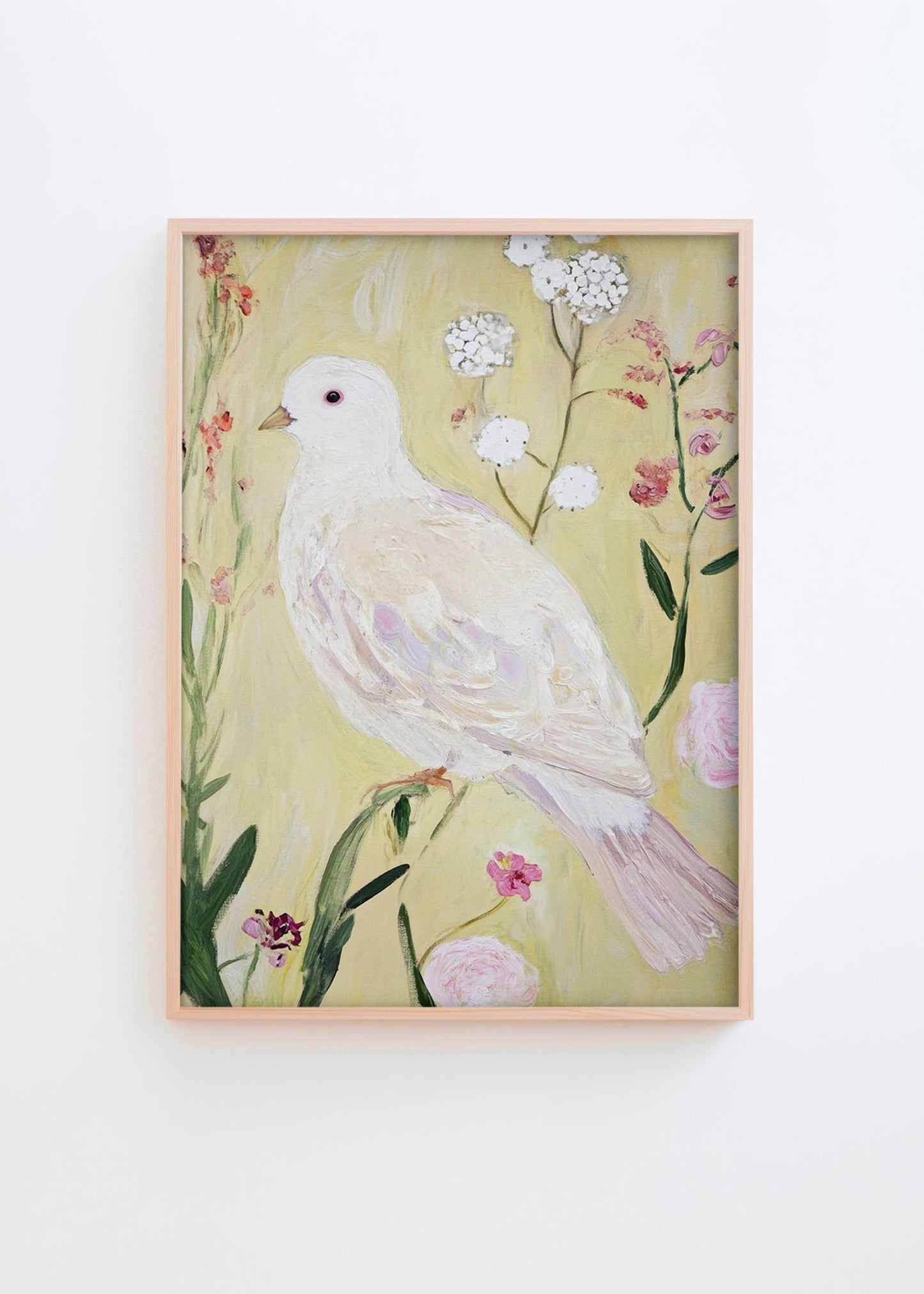 Garden Of Peace poster in natural oak frame styled on a white wall, featuring a white dove surrounded by soft pastel flowers in a bright Scandinavian interior by Hello Poster