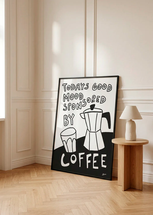 Good Mood by Athene Fritsch – framed black and white coffee poster with a moka pot, cup and the words Today's Good Mood Sponsored By Coffee, styled in a warm neutral interior with natural wood details.