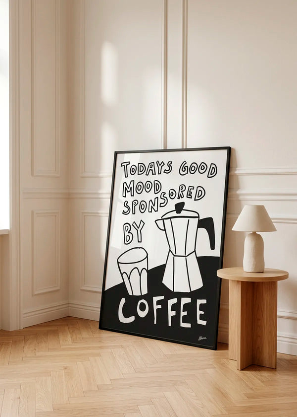 Good Mood by Athene Fritsch – framed black and white coffee poster with a moka pot, cup and the words Today's Good Mood Sponsored By Coffee, styled in a warm neutral interior with natural wood details.