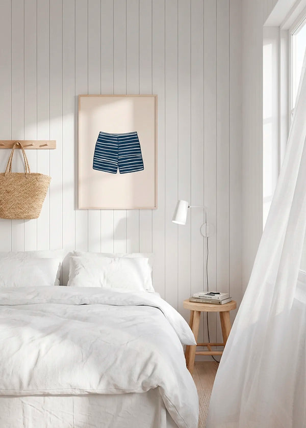 Striped swim shorts poster in oak frame styled above bed in bright Scandinavian bedroom, calm summer house interior decor