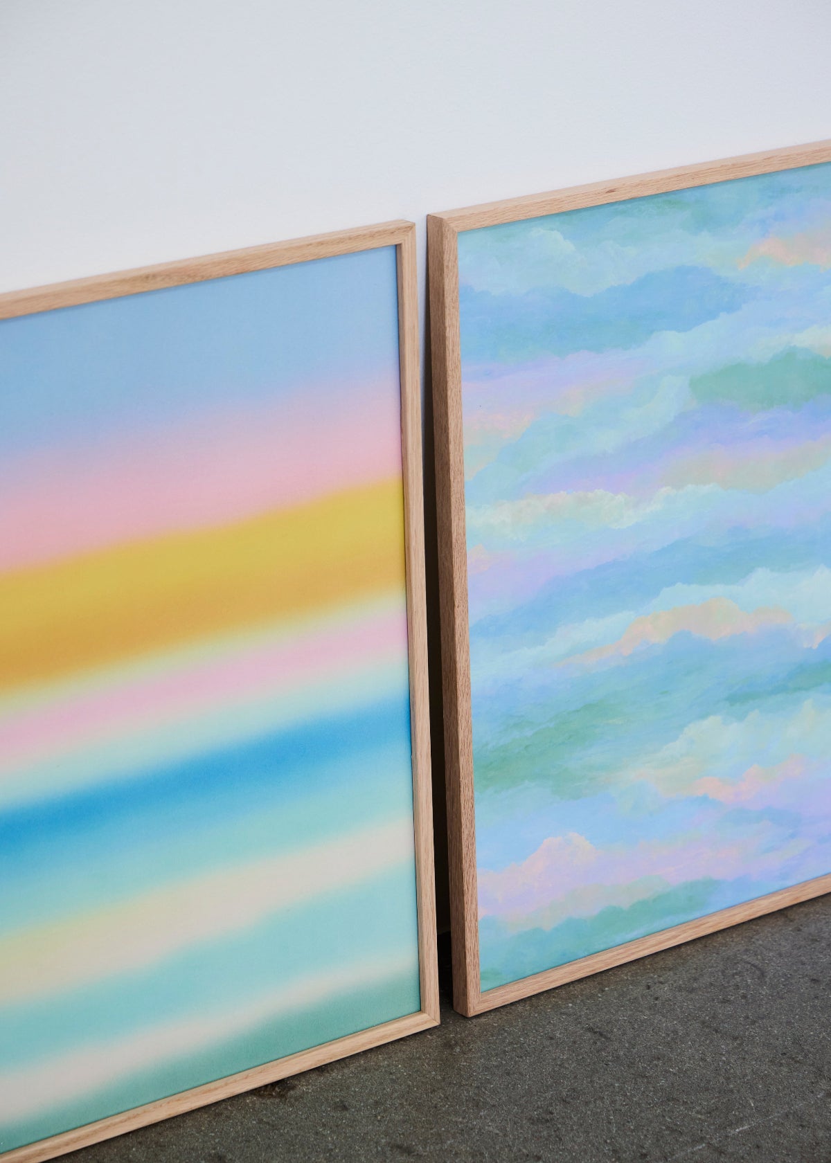Layers and Behind the Cloud posters from HelloPoster in oak frames, featuring pastel gradient design and soft sky-inspired artwork, styled side by side against white wall