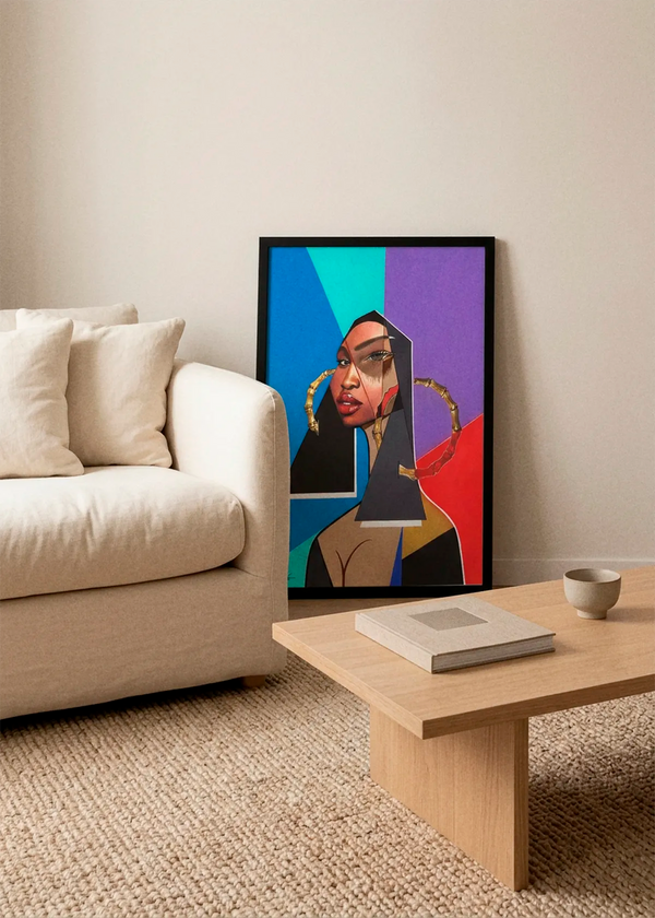 Modern Geometric Beauty by Manasseh Johnson Sr. art print featuring a striking female portrait with geometric shapes in blue, teal, purple and red, displayed in a black frame beside a cream sofa in a Scandinavian living room.