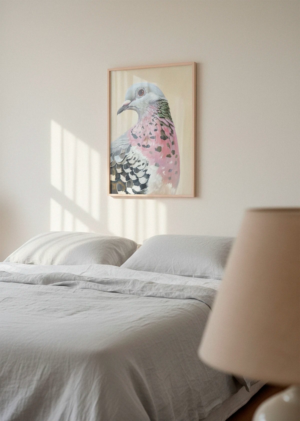 The Pigeon poster hanging in a calm bedroom environment with gentle morning light on a white wall.