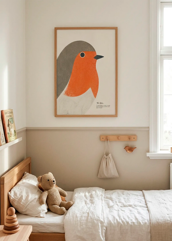Red Robin New Beginnings art poster by Ohkimiko displayed in a calm children’s bedroom with natural wood furniture, soft beige tones, white bedding and warm daylight.