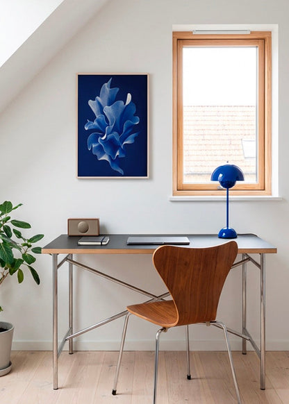 Shape No. 80 abstract blue wall art in oak frame styled above modern desk with wooden chair and blue lamp in bright Scandinavian home office.