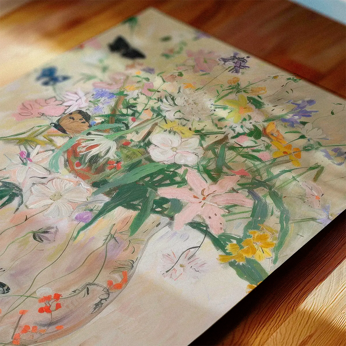 Colorful floral and bird-themed ‘Wild Garden’ art print displayed flat on a wooden table with sunlight and leaf shadows for a natural, cozy look.
