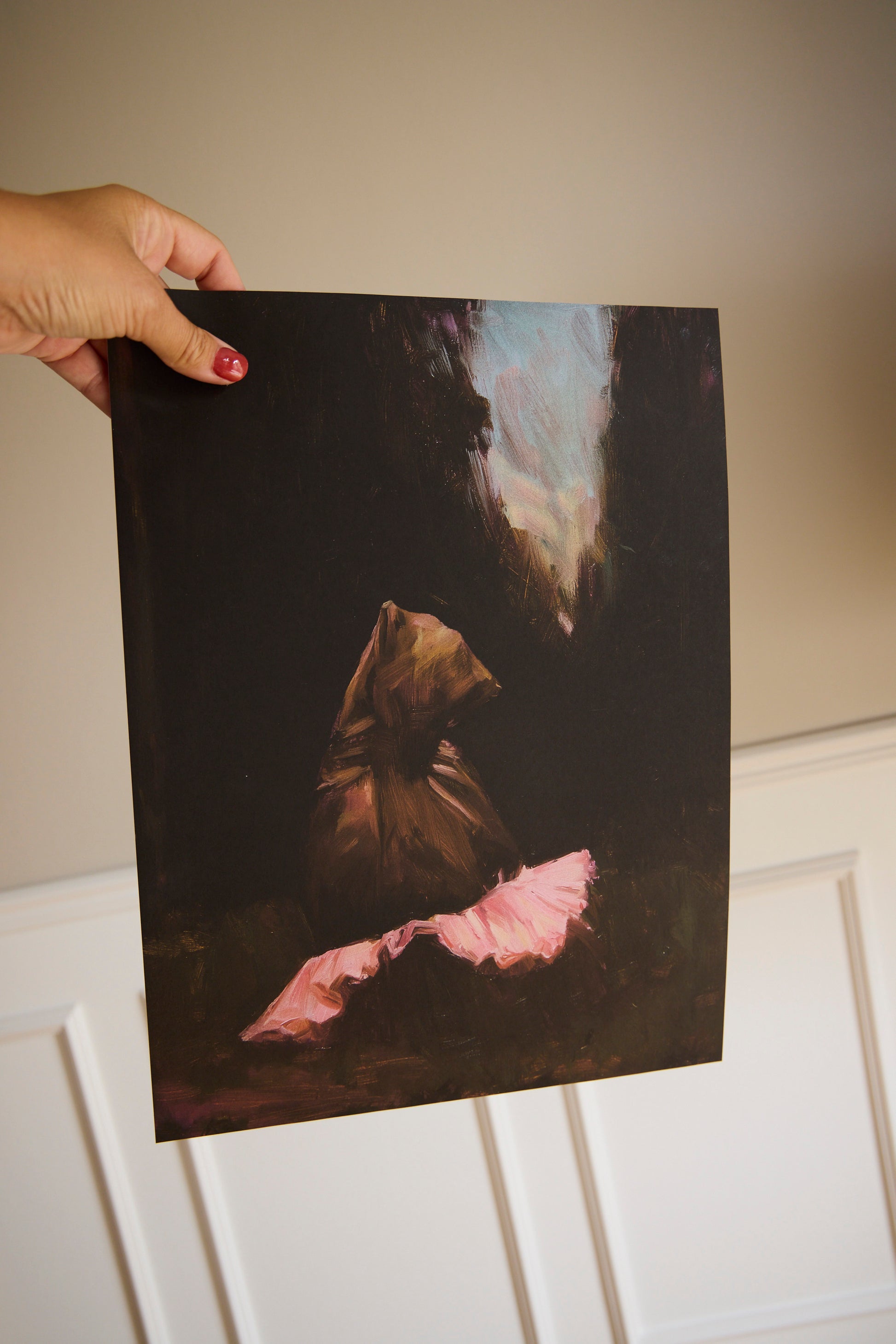 Bear With Me bear poster held by hand, featuring a dark brown bear wearing a pink ballet tutu.