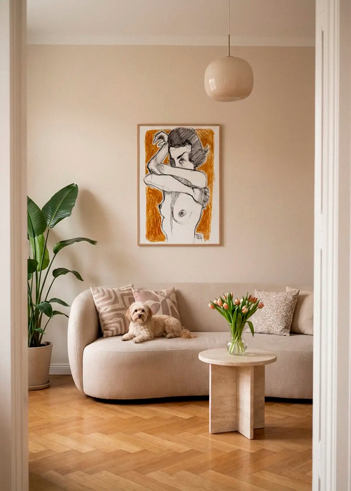 Crossed Arms poster styled above a sofa in a warm Scandinavian living room with natural wood floors