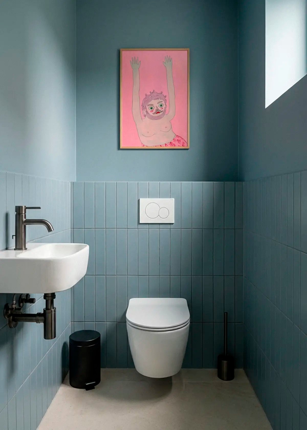 Jerry poster styled above the toilet in a modern Scandinavian bathroom with blue tiles