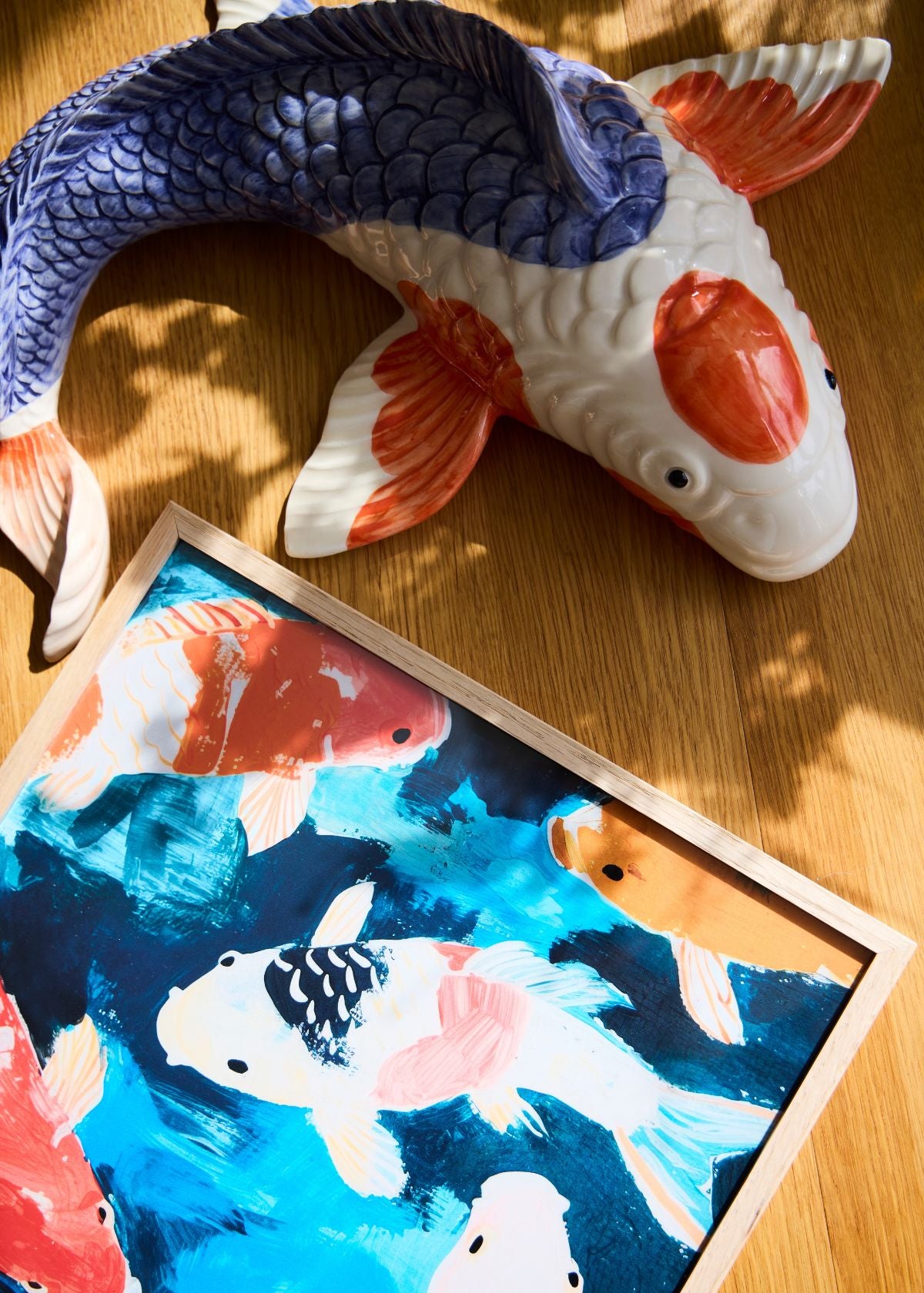 Close-up of the “Koi” poster featuring colorful koi fish painted in vibrant blue, orange, and white tones in a wooden frame.