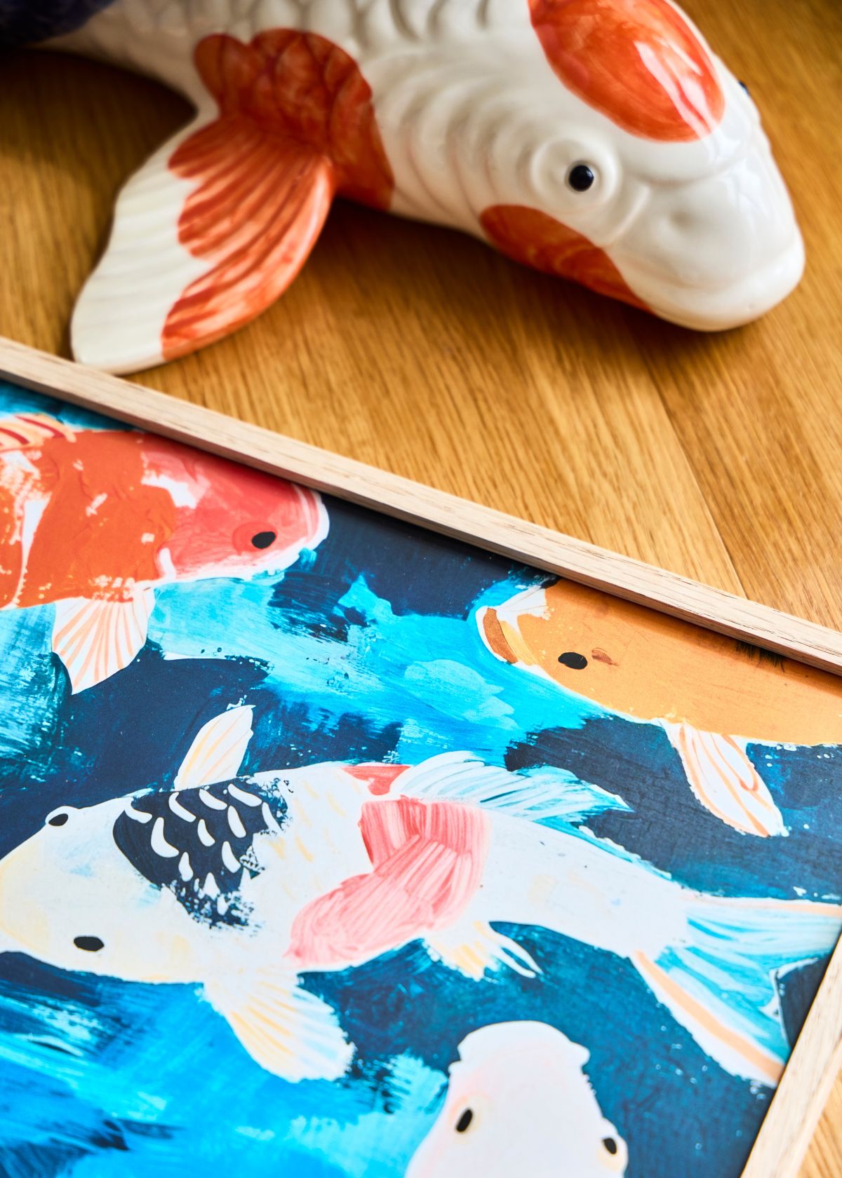 Detail shot of the “Koi” poster showing vivid brushstrokes and red, white, and blue koi fish swimming across a deep blue background.