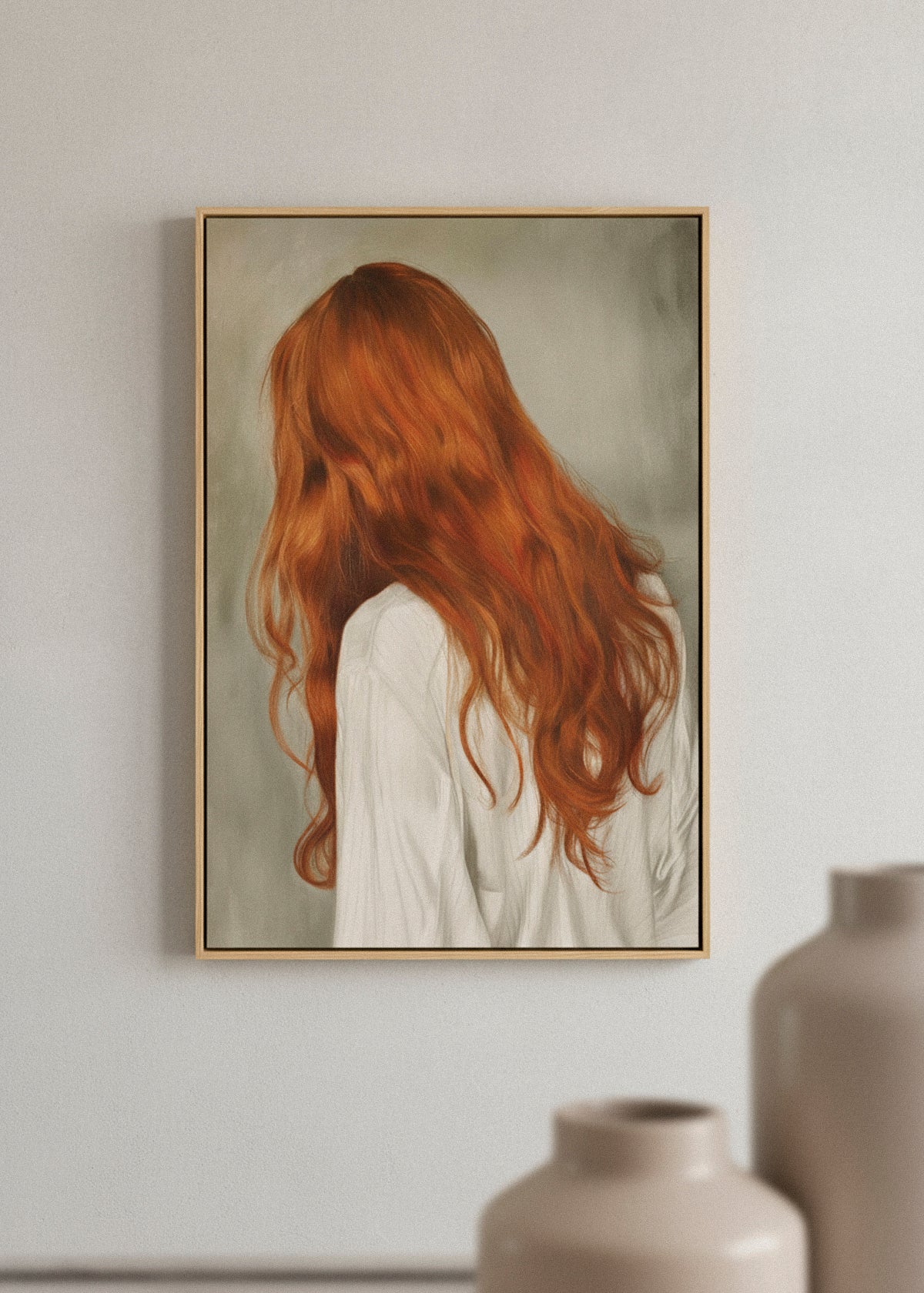 Framed “Red Hair” canvas print hanging above a beige sofa in a cozy living room styled with warm neutral tones.